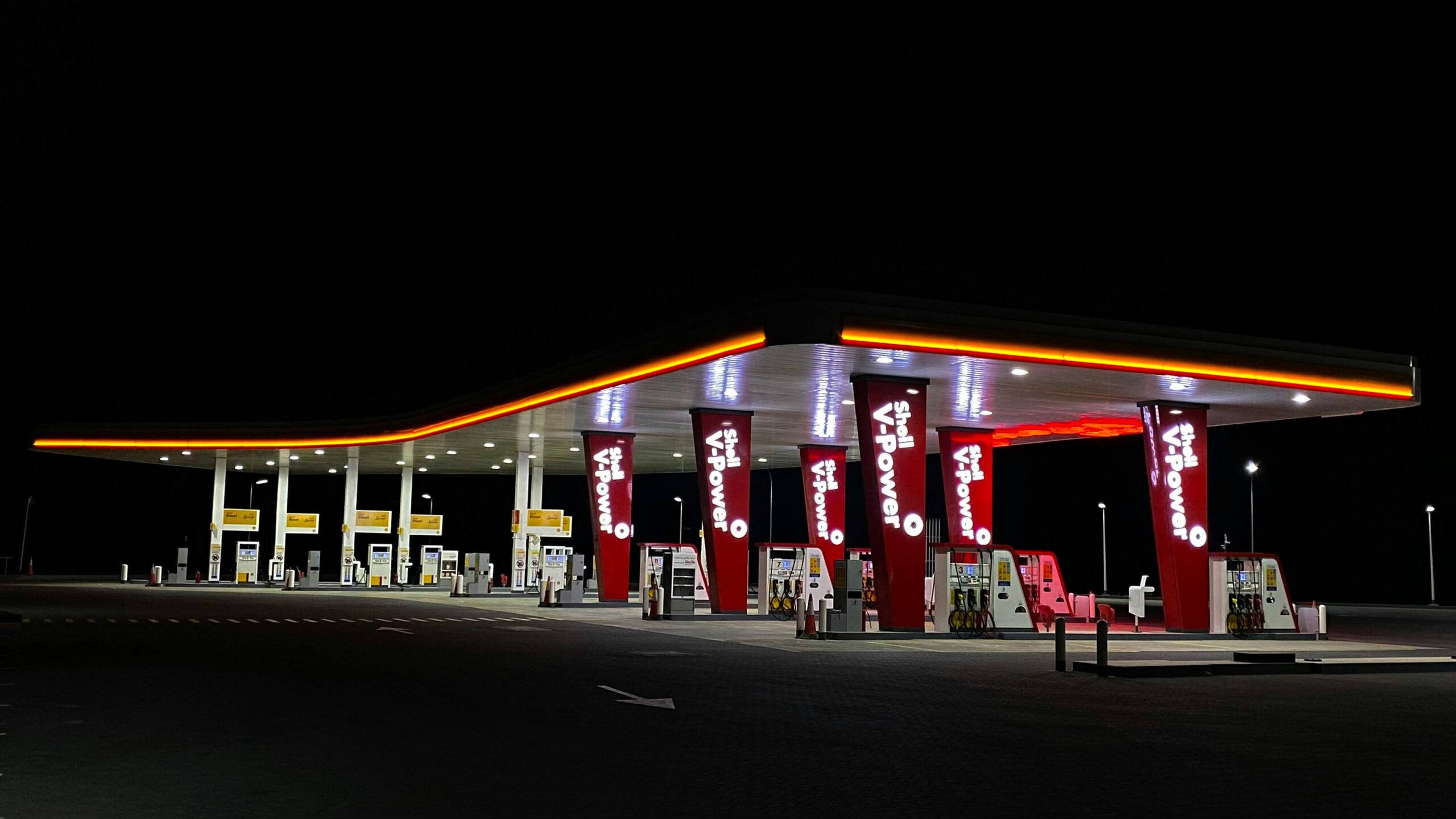 A brightly lit Shell petrol station in Muscat, Oman, photographed at night.